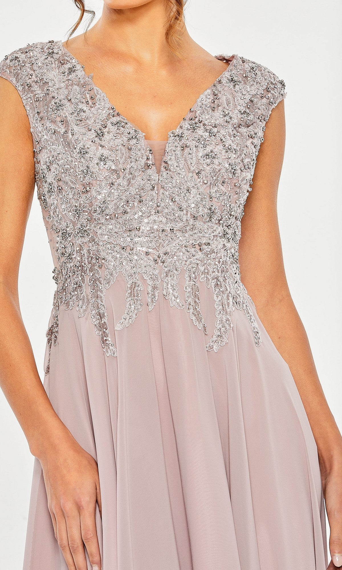 A woman wears the Mac Duggal 20492 Midi Wedding Guest Dress, a sleeveless lavender gown with an embellished v-neck bodice and flowing chiffon skirt.
